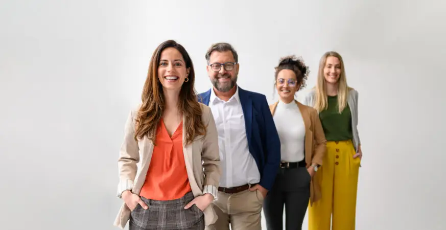 Portret al unor persoane de succes în domeniul profesional, aliniați în șir, zâmbind, în spate un fundal alb.