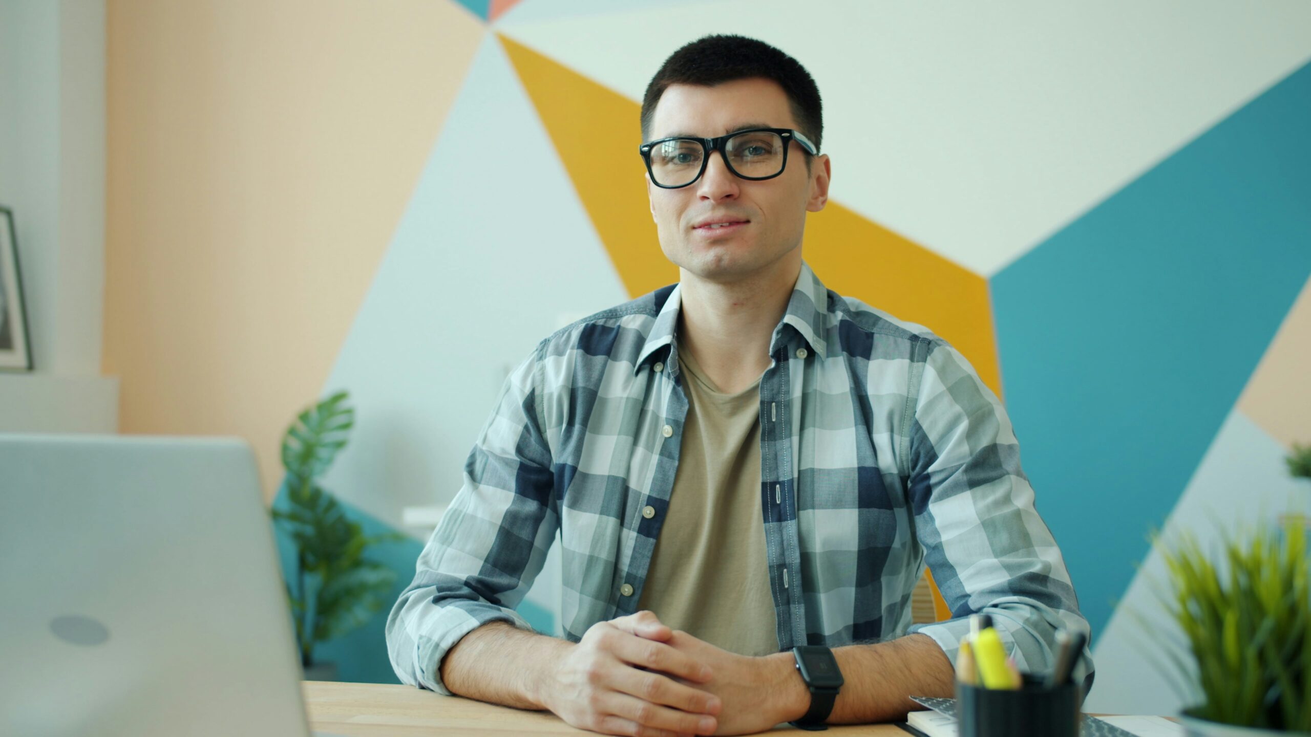 Bărbat așezat la birou, în fața unui laptop