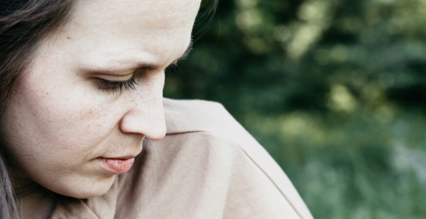 Imagine din profil a unei femei care se uită în jos